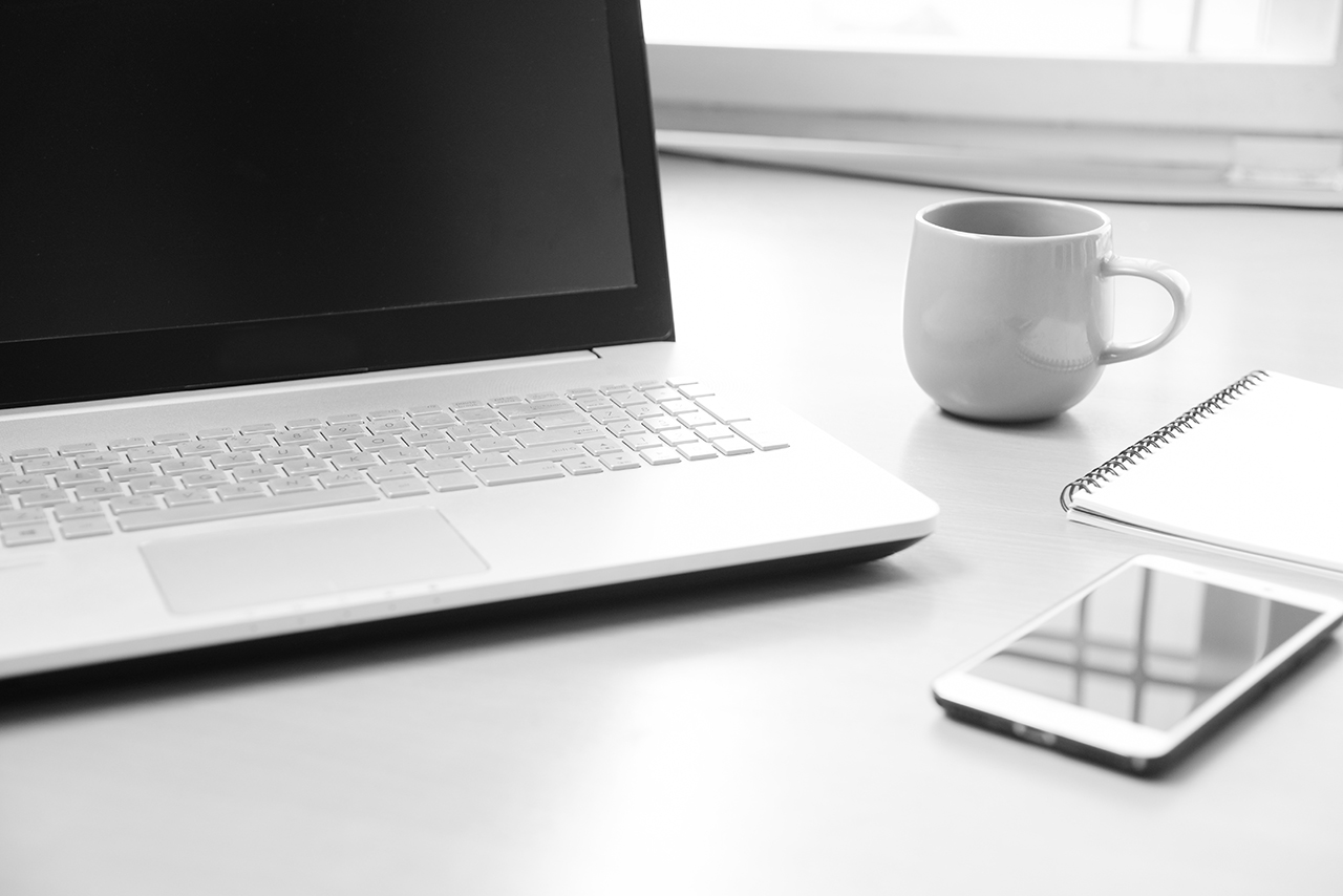 Business Notebook computer with smart phone , notebook paper for note message and a cup of coffee on wood desk backgroun